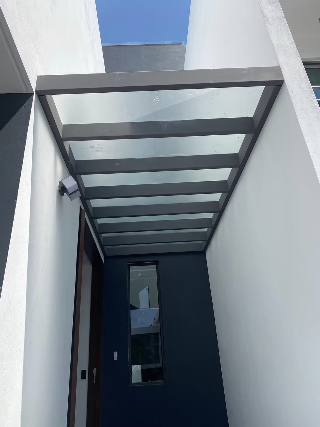 Domos de cristal en cubierta con estructura oscura sobre un acceso